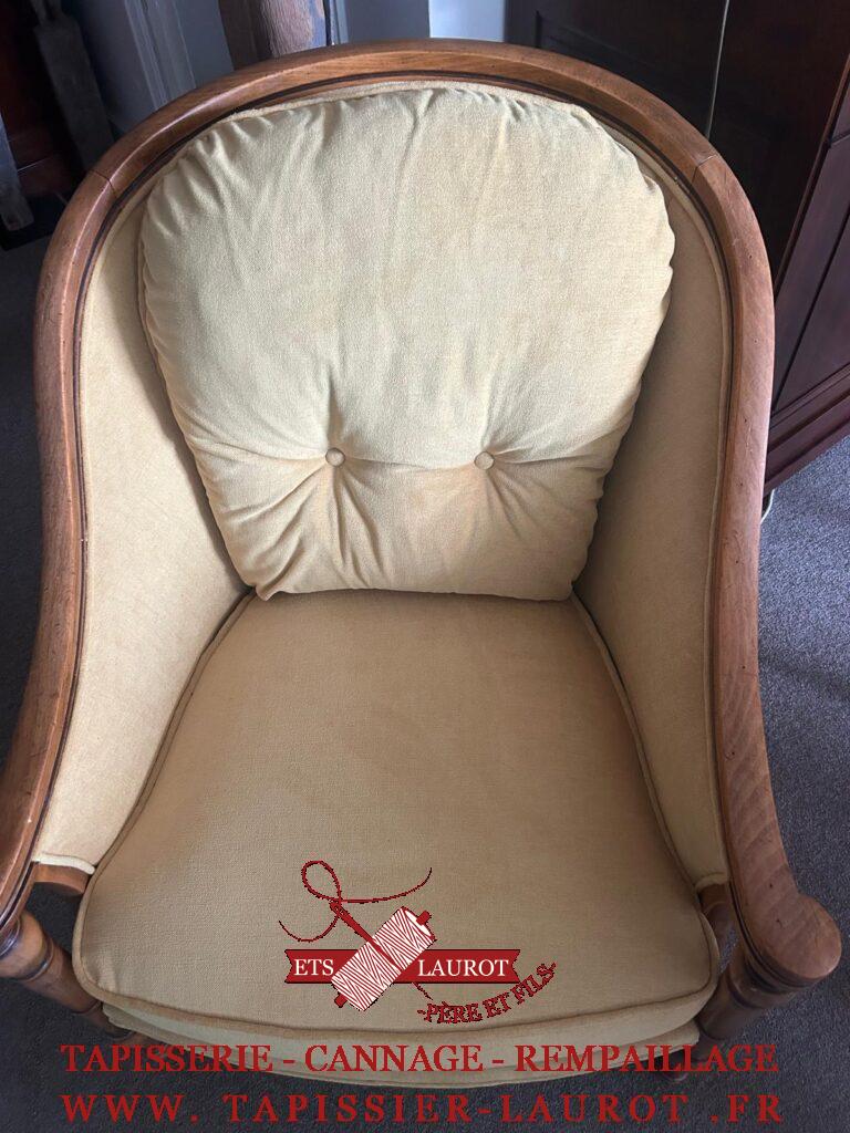 Bergère à coussin avant réfection, recouverte d’un tissu rayé à motifs floraux avec assise visiblement usée.
