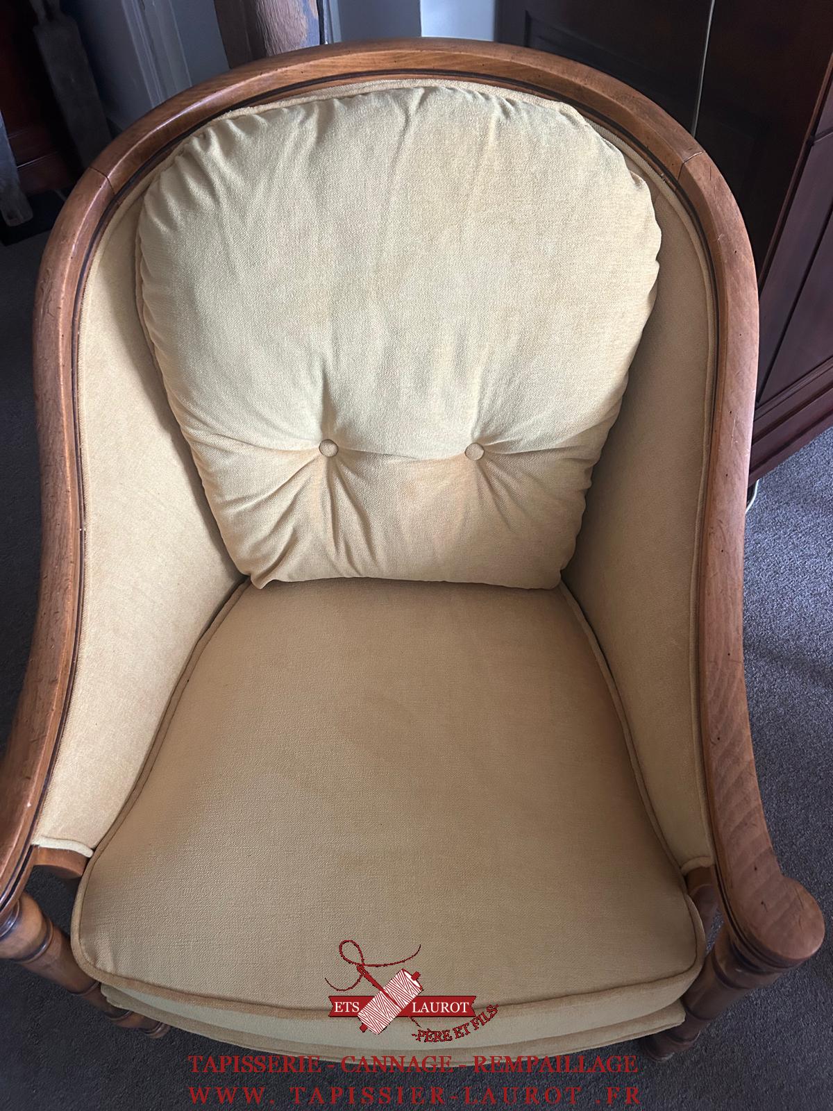 Bergère à coussin avant réfection, recouverte d’un tissu rayé à motifs floraux avec assise visiblement usée.