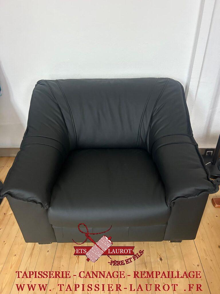 Fauteuil restauré en cuir noir, avec dossier enveloppant et accoudoirs arrondis
